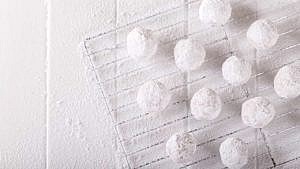 snowball cookies powdered with sugar on a cooling rack on a white table, snowball cookies recipe