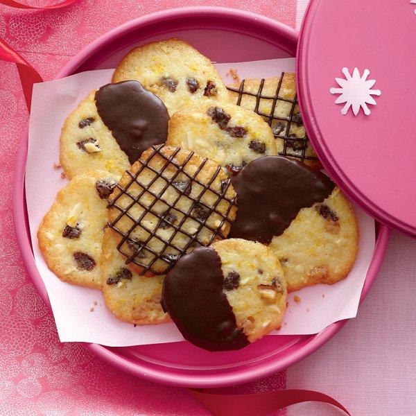 A pink cookie tin filled with chocolate dipped cherry-almond florentines.