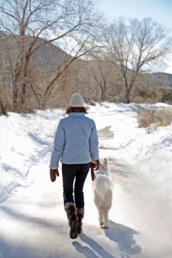 woman walking with dog winter snow outdoors