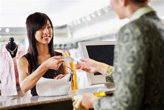 asian woman shopping with credit card at retail store