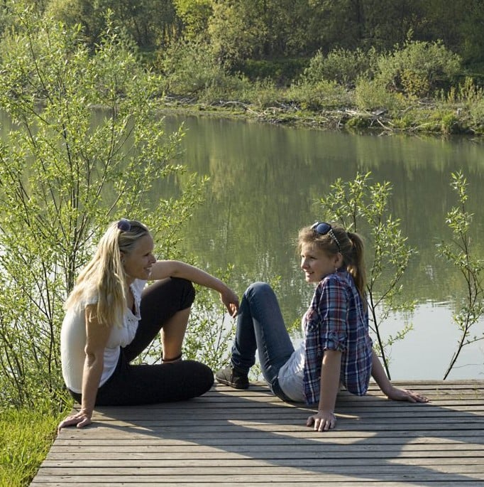 Mother and daugther talking by a lake