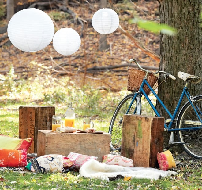 Backyard picnic with bike, crates, blankets, cider, glass jars