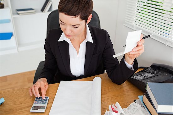 business woman with calculator receipt in office