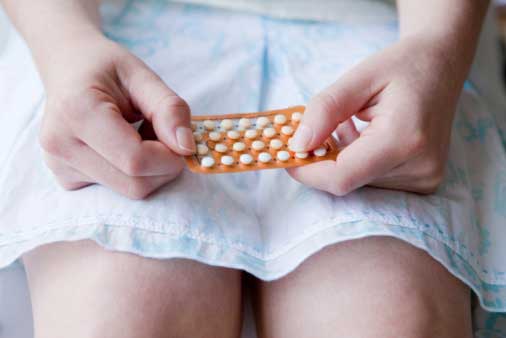 Woman holding a package of birth control pills