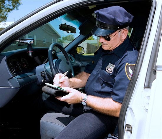 Police Officer writes a ticket in his cruiser