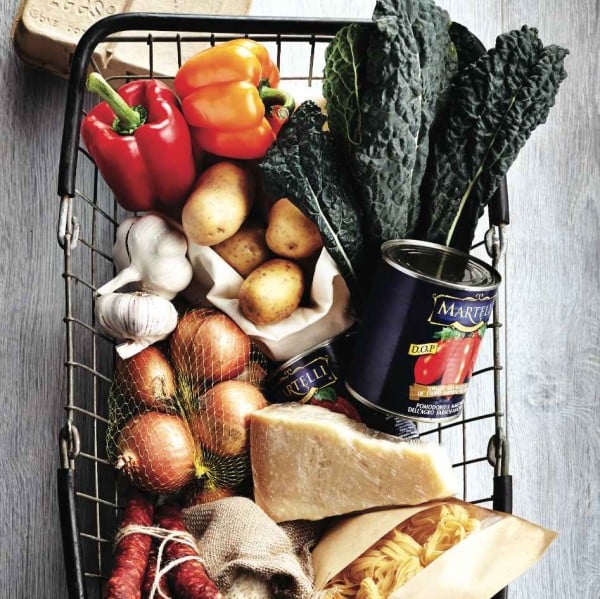 How max out the shelf life of fruits and vegetables: Image of a grocery basket filled with kale, cheese, potatoes, tomatoes, garlic and peppers
