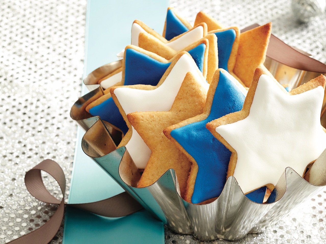 royal icing decorated start-shaped sugar cookies in a small brioche tin