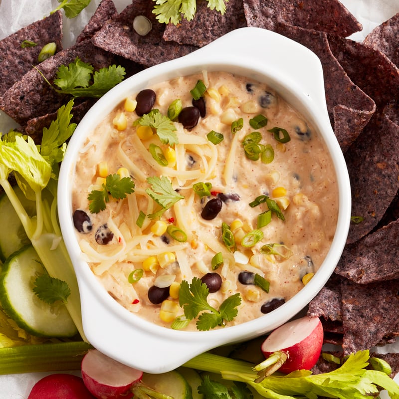 Southwest corn and bean cream cheese dip with vegetables and tortilla chips