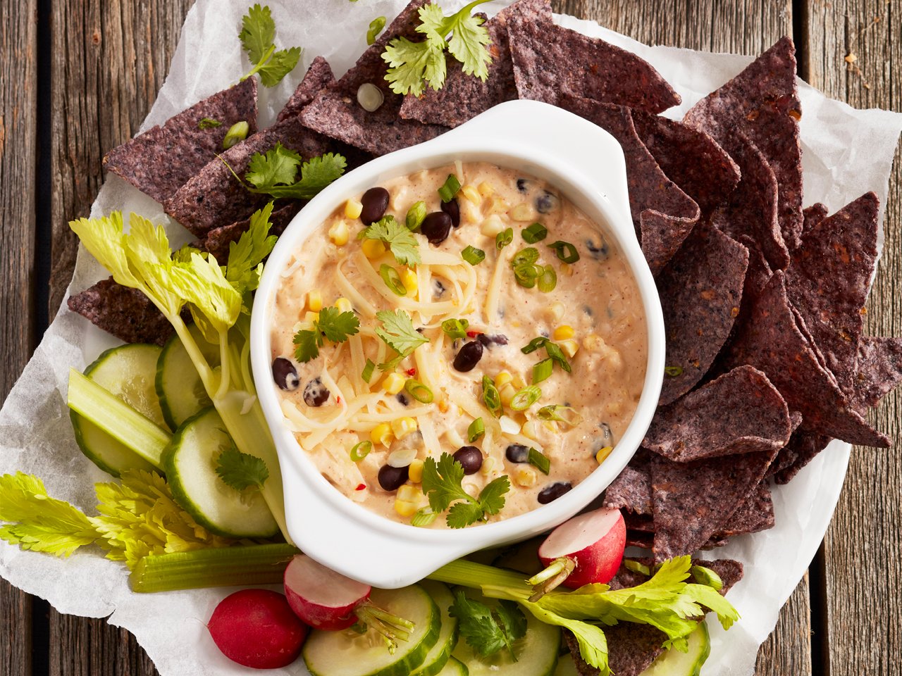 southwest corn and bean cream cheese dip with vegetables and tortilla chips