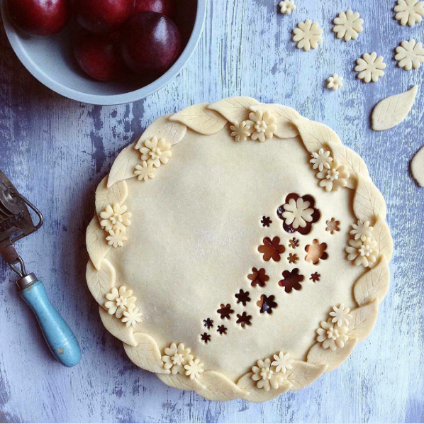 decorative pie crusts: plum pie with leaves and flowers around edge of pie with flower cut outs in middle