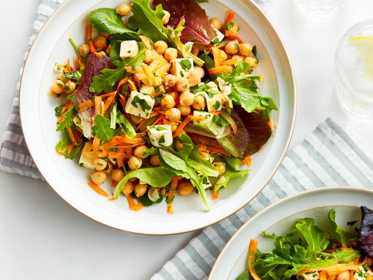 Carrot, halloumi and chickpea salad on a plate with striped grey and white napkins