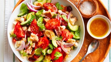 Summer dinner recipes like this Tuna panzanella salad are irresistible. Served in large white bowl on a circular wooden platter