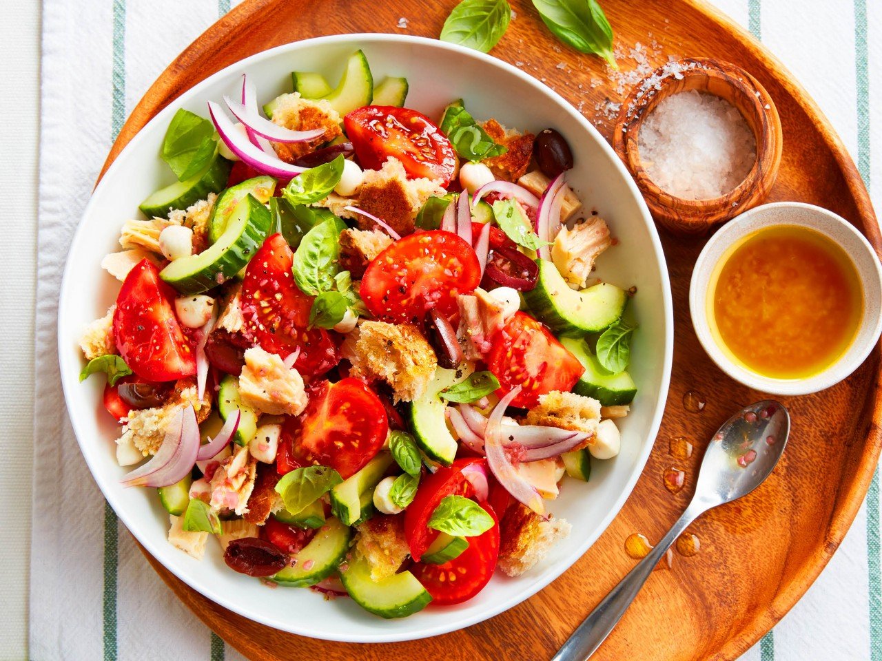 Summer dinner recipes like this Tuna panzanella salad are irresistible. Served in large white bowl on a circular wooden platter