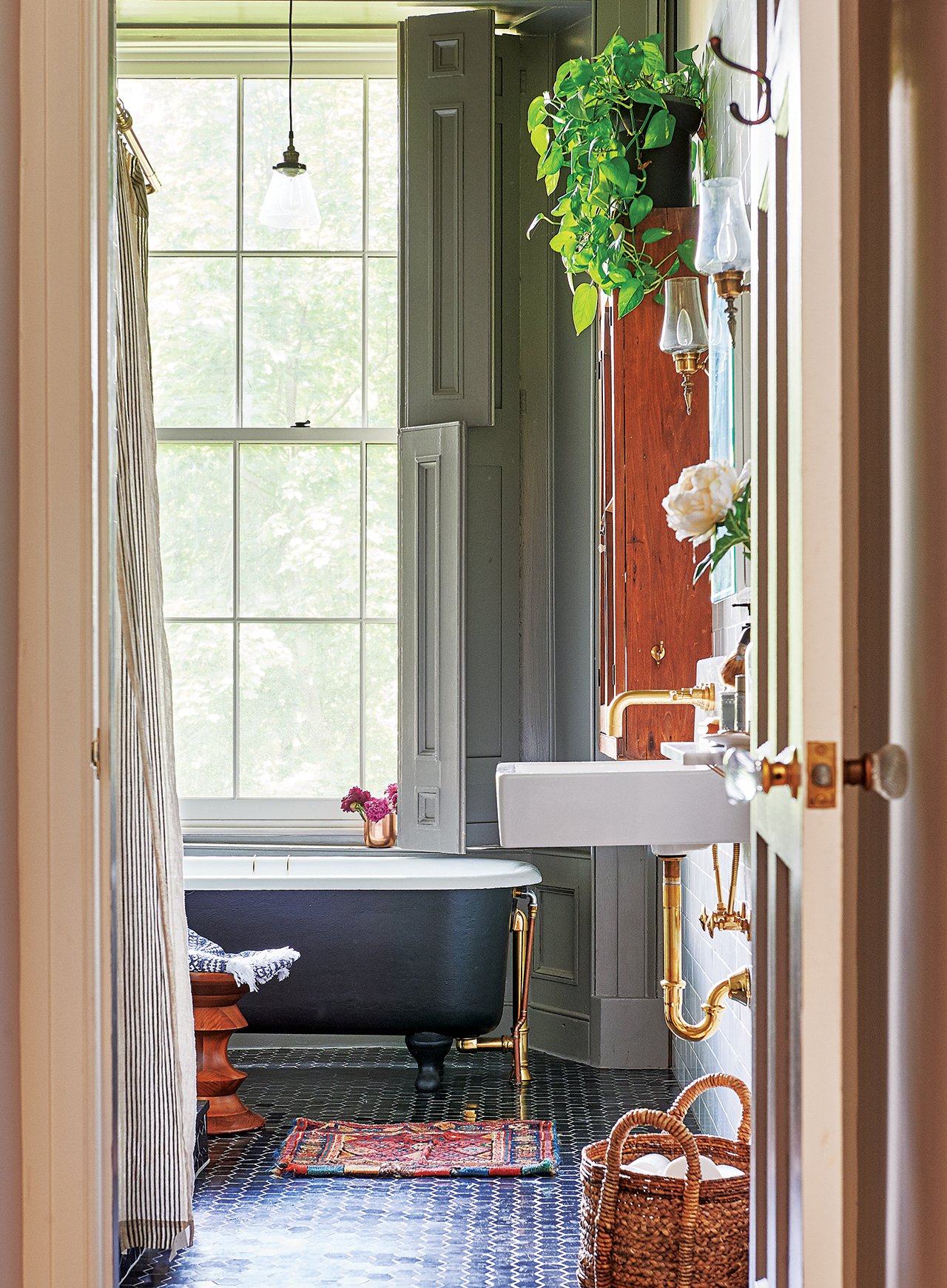 A glimpse into the stone house's bathroom, with big windows and a footed tub.