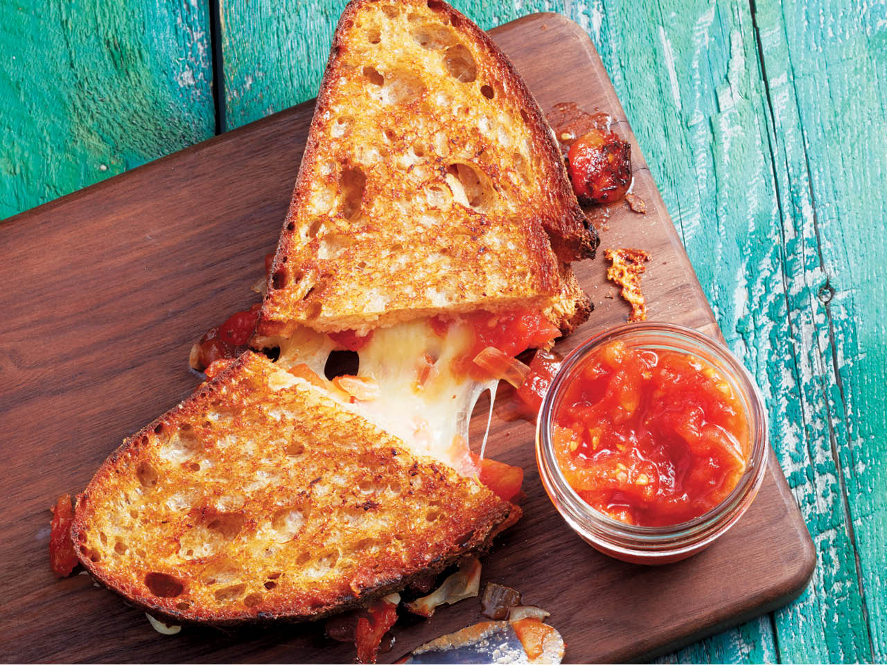 Melted cheese inside a grilled cheese with tomato jam