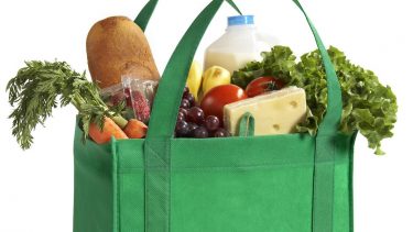 Green bag filled with groceries.