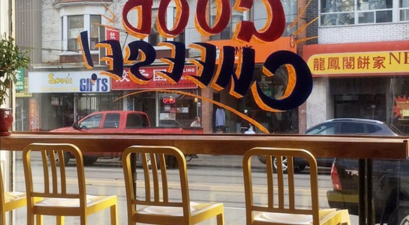 Three yellow chairs in front of a window sign that says Good Cheese!
