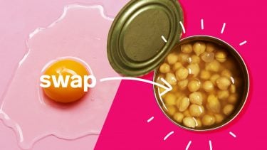 Cracked egg with arrow pointing to can of chick peas on pink background