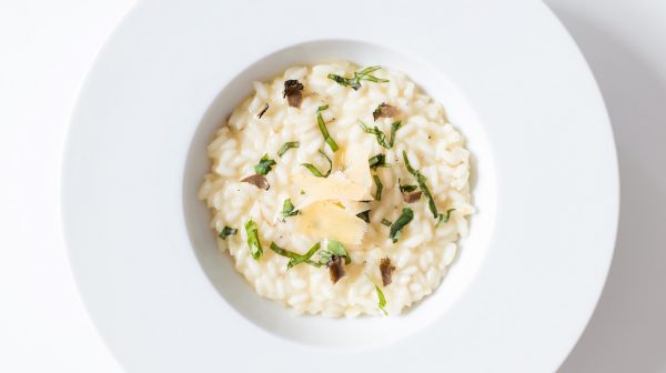 how to make classic risotto: risotto in a bowl with parmesan and herbs on top