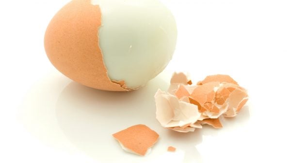A photo of an Instant Pot boiled egg with half of its shell peeled off.