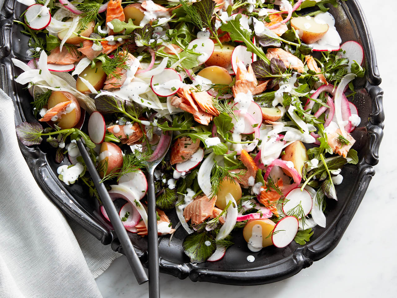 smokes trout salad with creamy horseradish dressing on dark serving plate