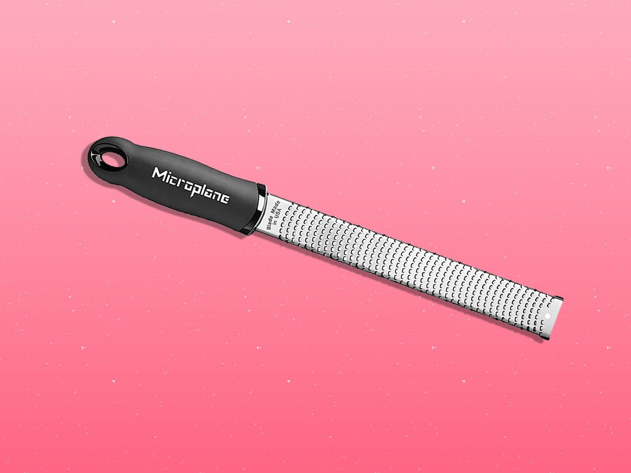 Microplane grater on pink background.