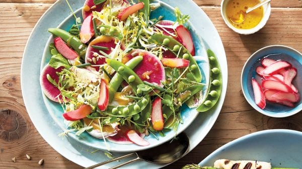 Spring rhubarb salad in a blue bowl on a wooden table