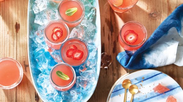 strawberry-rhubarb sangria jellies in champagne coupe glasses on a large serving tray filled with ice