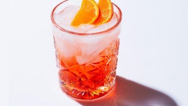 Aperol spritz topped with orange wedges for a piece on the recipe