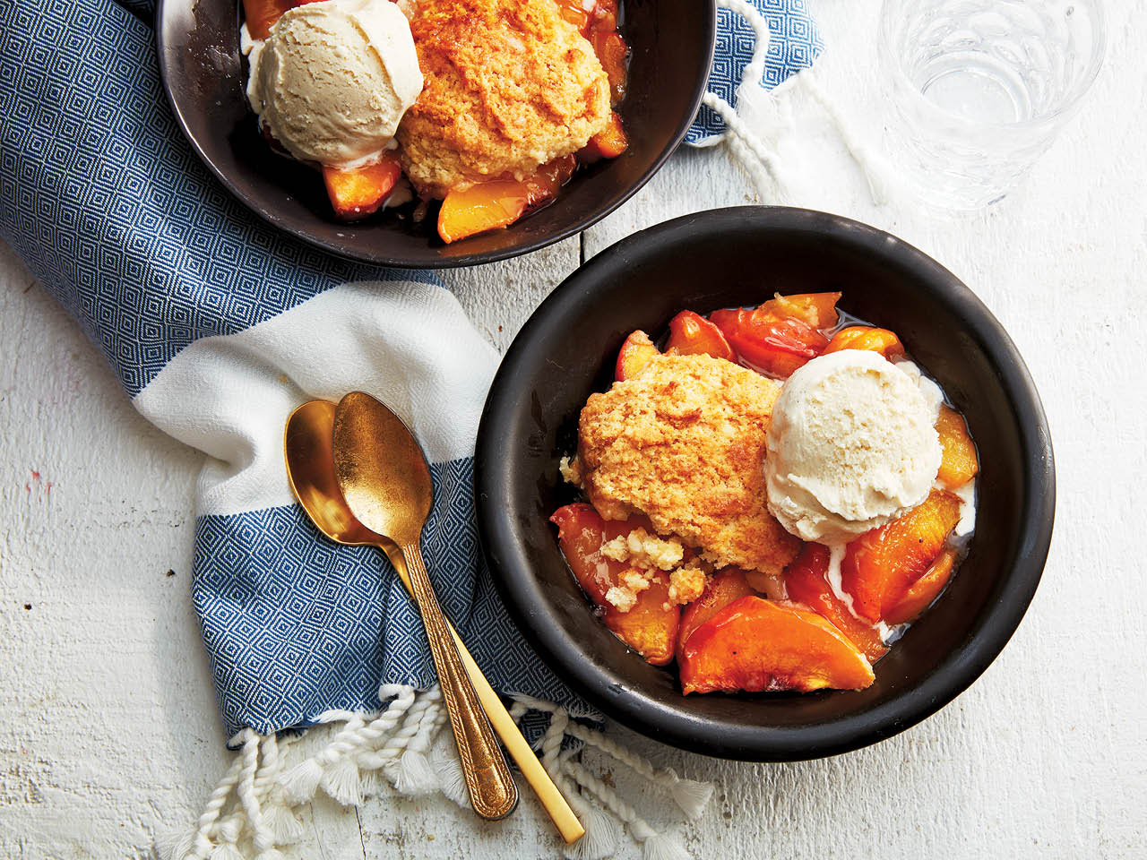 Cobbler recipes: Classic peach cobbler topped with ice cream in a black bowl