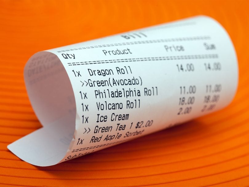 How much to spend dining out feature photo of a sushi receipt on an orange background
