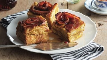 Three slices of slow cooker French toast topped with bacon.