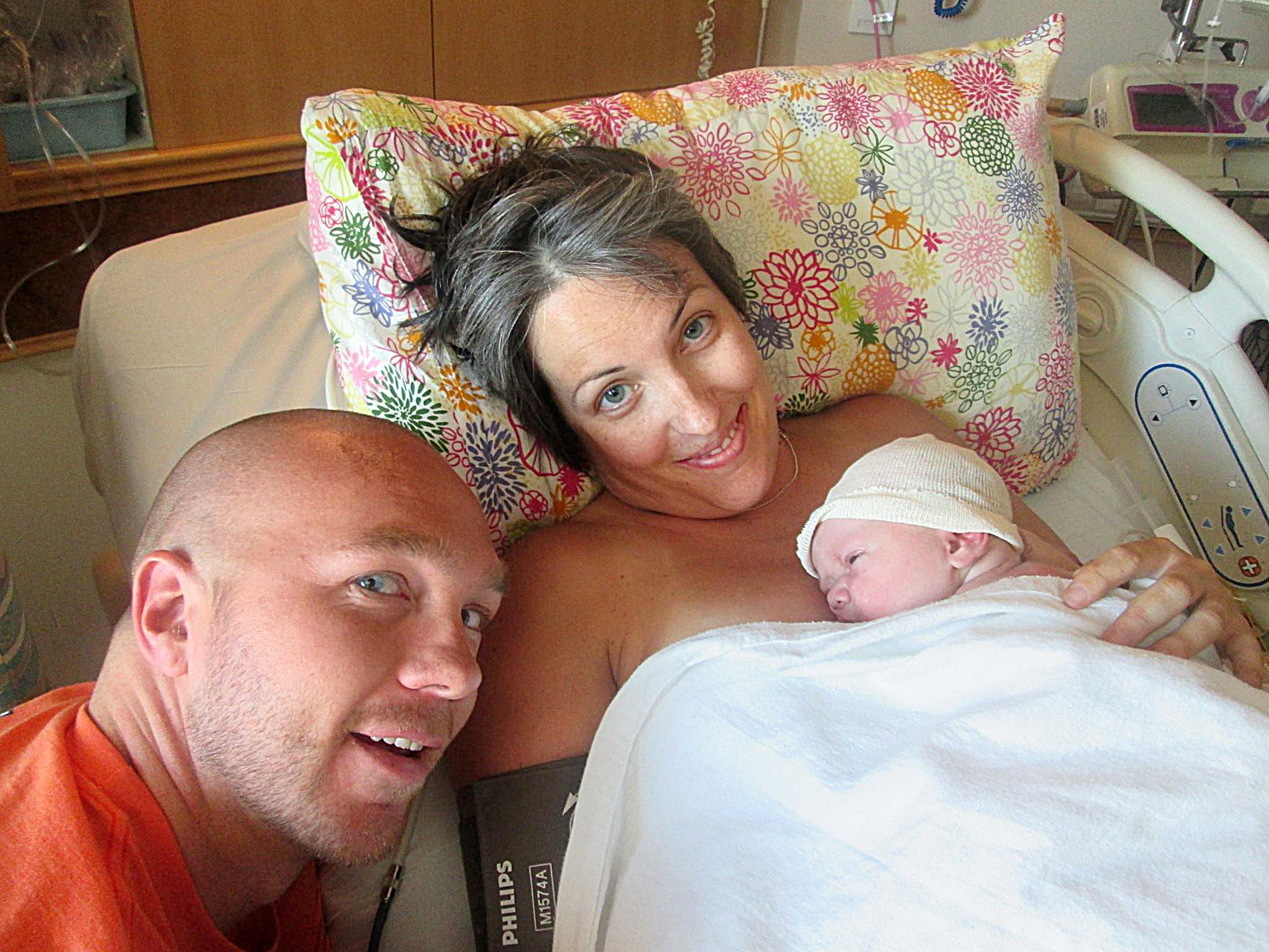opioid addiction sigma-a man and a woman pose with their newborn baby at the hospital