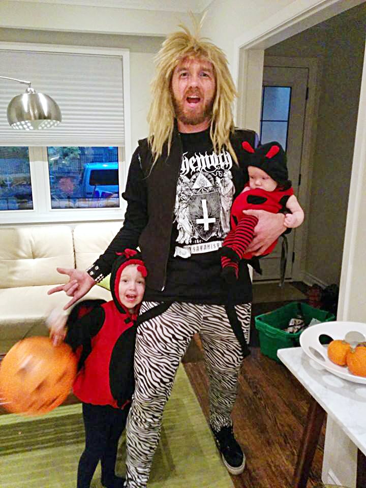 opioid addiction stigma-a man waring a hair metal costume poses with two little girls in ladybug costumes