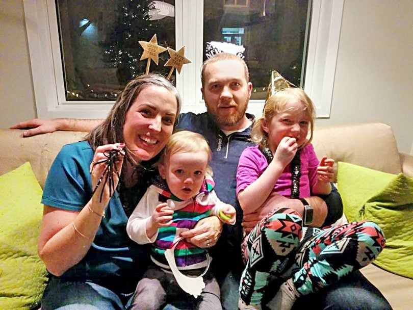 opioid addiction stigma-a family of four sit on a couch with New Years Eve decorations