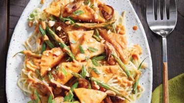 best tofu recipes: Crispy tofu stir fry with peanut sauce on white oval serving plate
