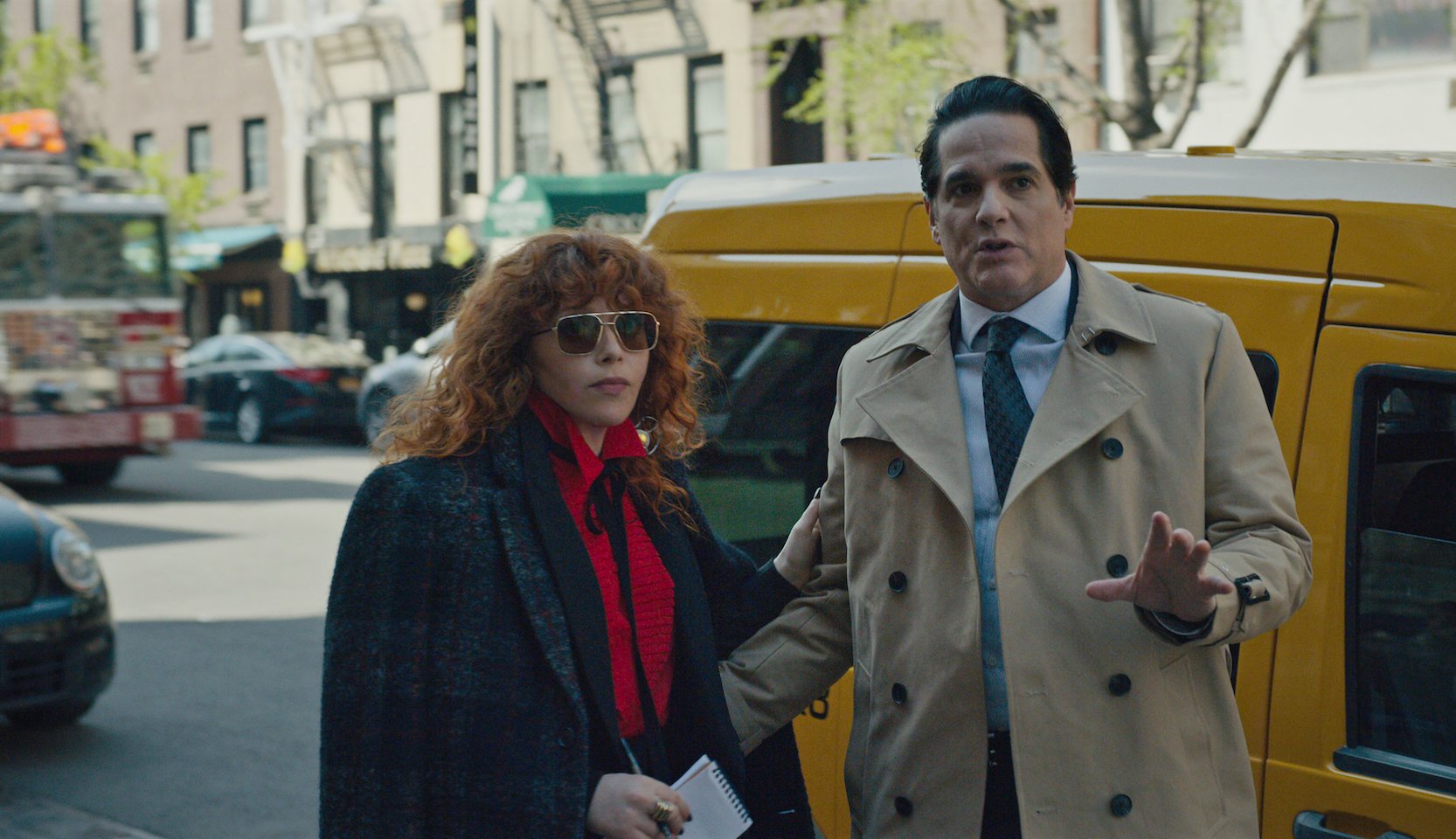 Netflix Russian Doll - a still from Netflix's Russian Doll shows a man and woman standing side-by-side outdoors near a yellow NYC taxi