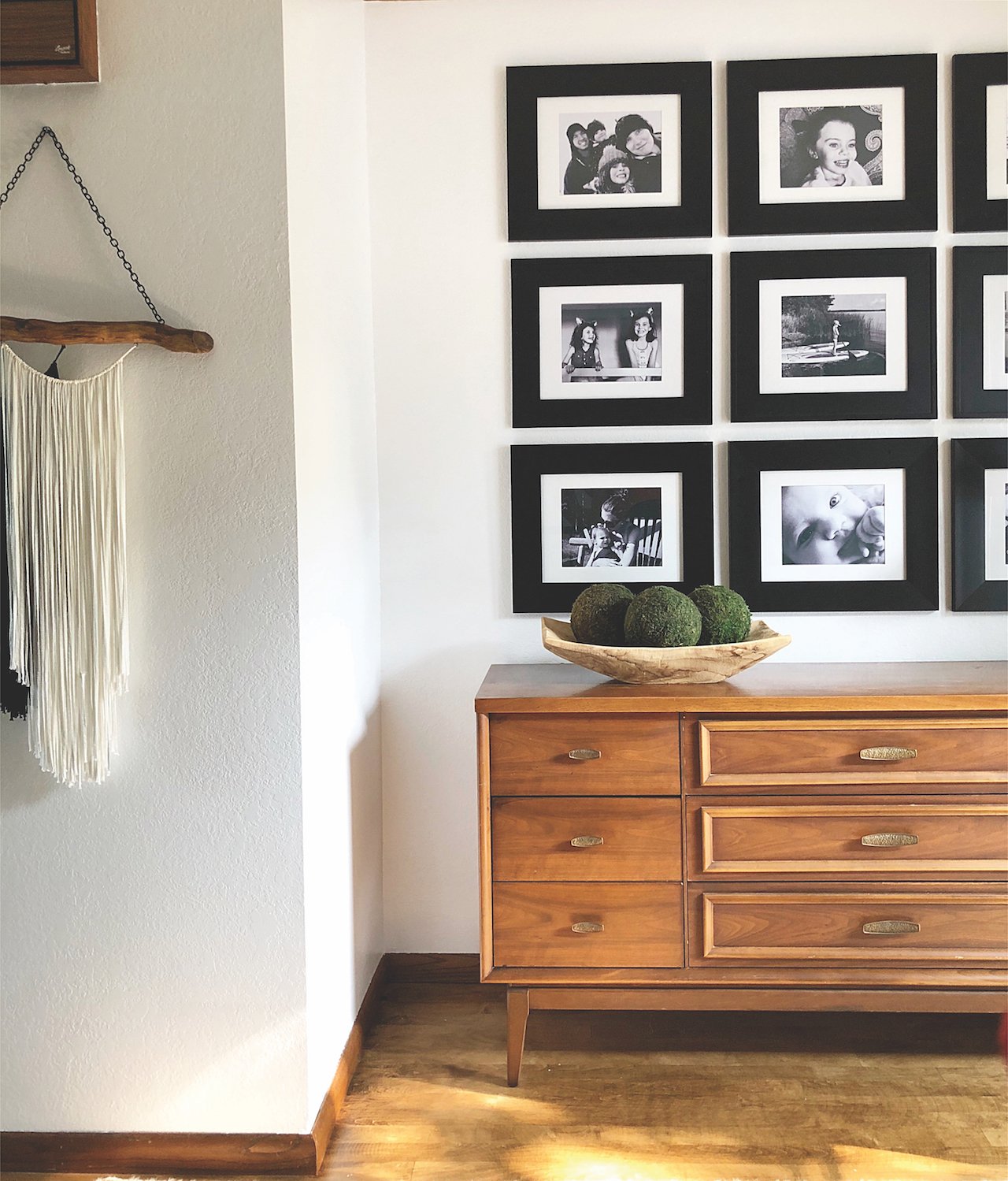 gallery wall-neatly ordered black frames fill a wall above a sideboard