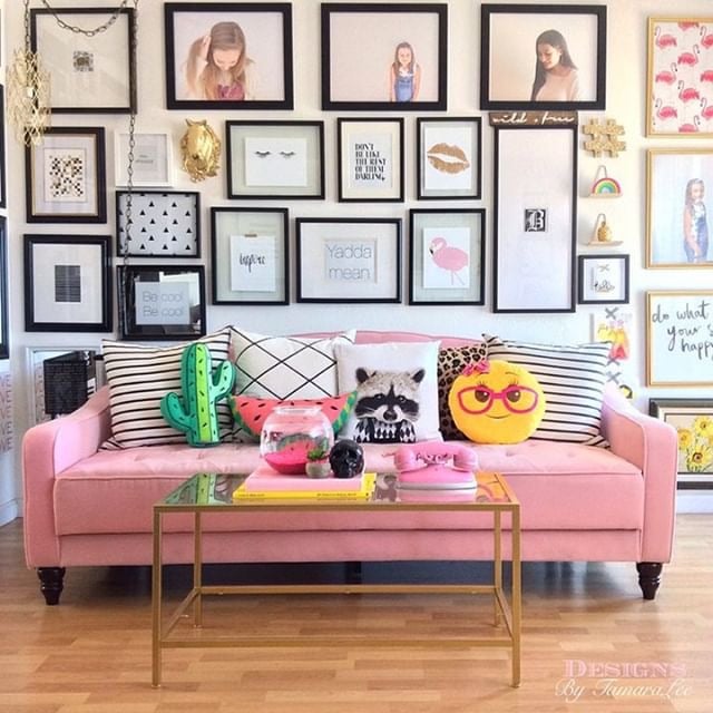 gallery walls-bright and bold display of framed artwork behind a pink couch