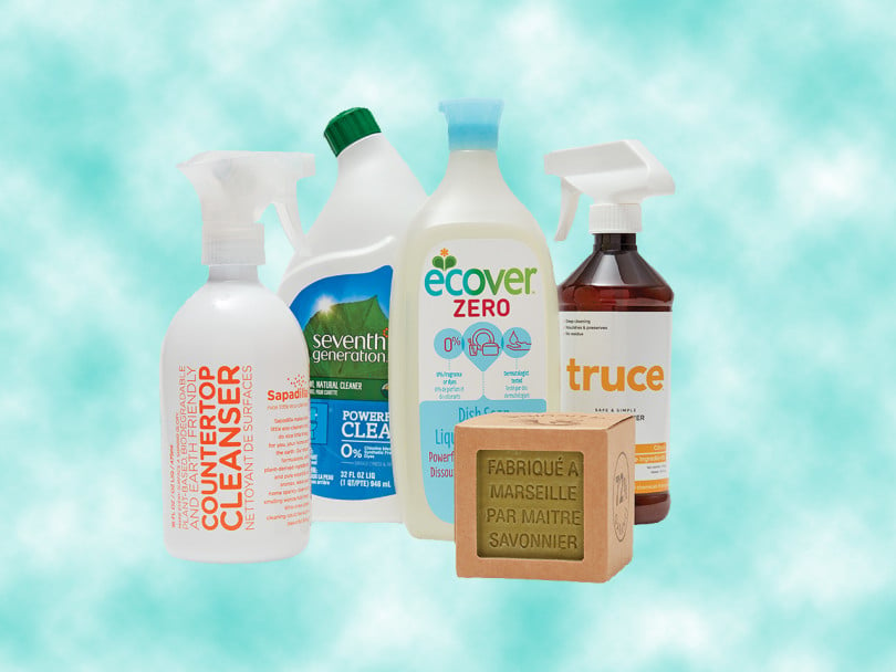 Eco-friendly cleaning products: 2 spray bottles, 1 toilet cleaner, 1 dish soap bottle, 1 soap cube on blue cloud background