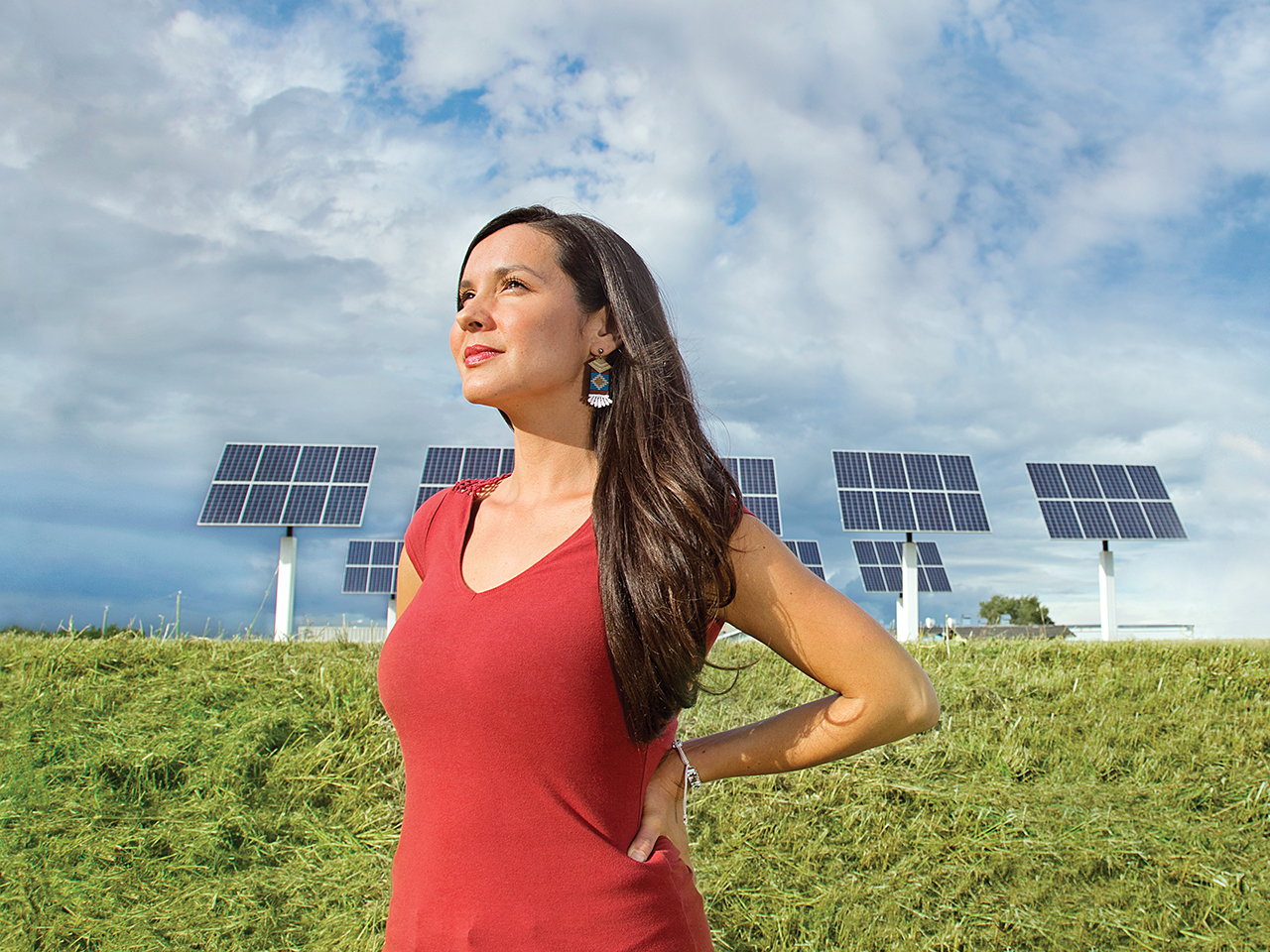 Entrepreneur Melina Laboucan-Massimo stands in front of outdoor solar panels