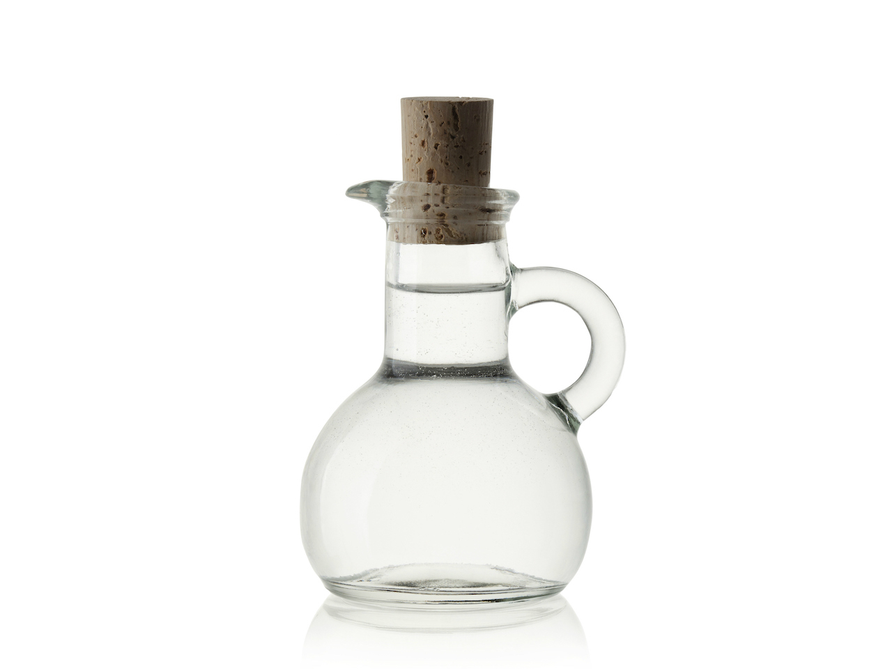 Clear vinegar in a glass jar with a handle that is sealed with a cork.