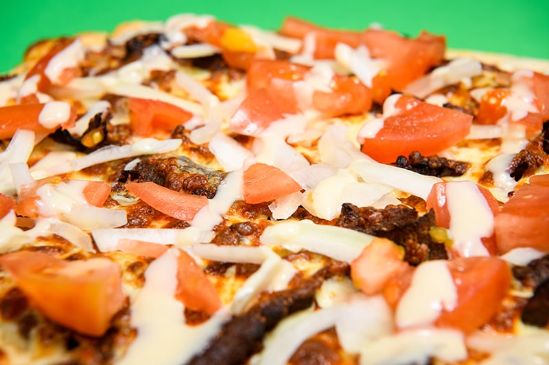 Regional Canadian pizza: donair pizza pie closeup with green background