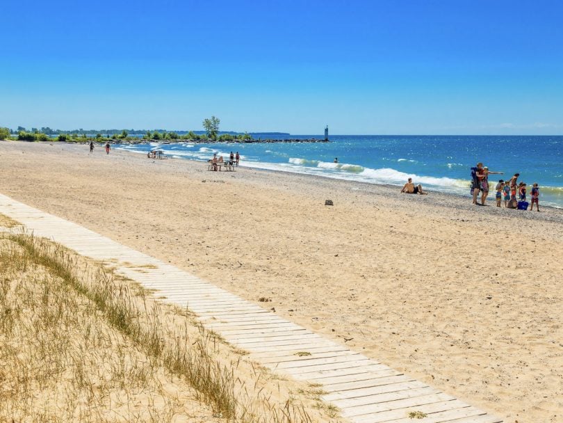 secret beaches in Canada-Prince Edward County-Ontario-Wellington Beach is a long sandy stretch with a small boardwalk and blue sky and blue water