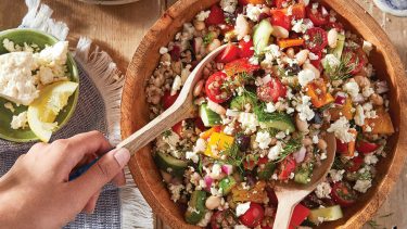 Overhead shot of a wooden bowl filled with Greek Salad with Toasted Buckwheat