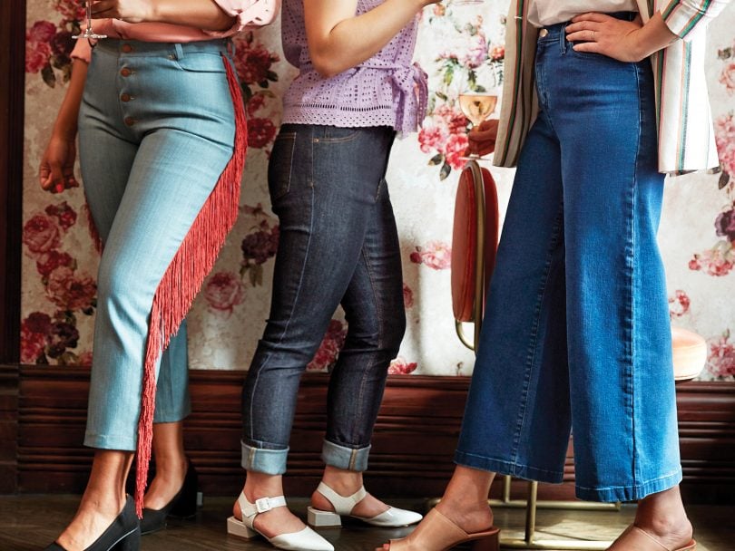 Photo of three women wearing Canadian denim in front of a floral wallpaper background and dark wooden floors.