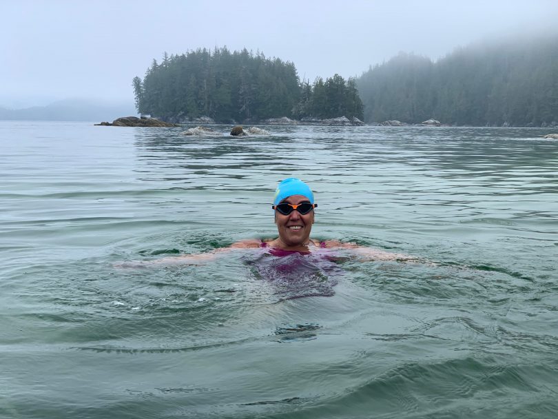 Susan Simmons treading water in a cold lake, smiling at the camera.
