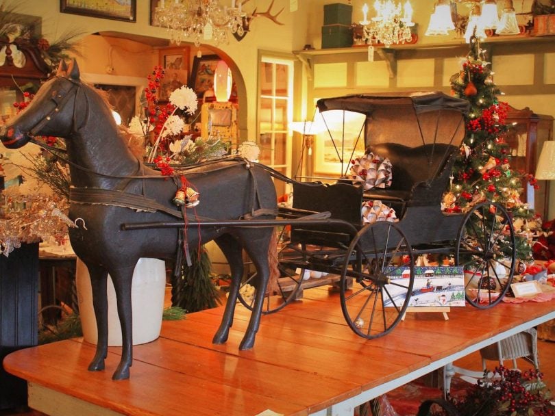 a model size horse and cart inside an antique store
