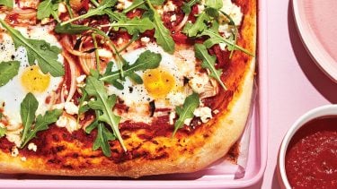 Homemade pizza recipes: Pink tray topped with pizza and eggs.