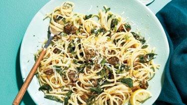 Linguine and with spinach on light blue plate.